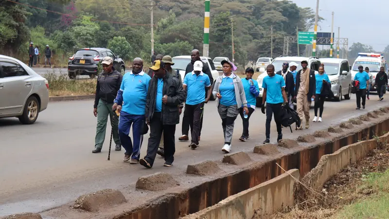 Walk for Fitness participants in blue shirts walking along a Nairobi road